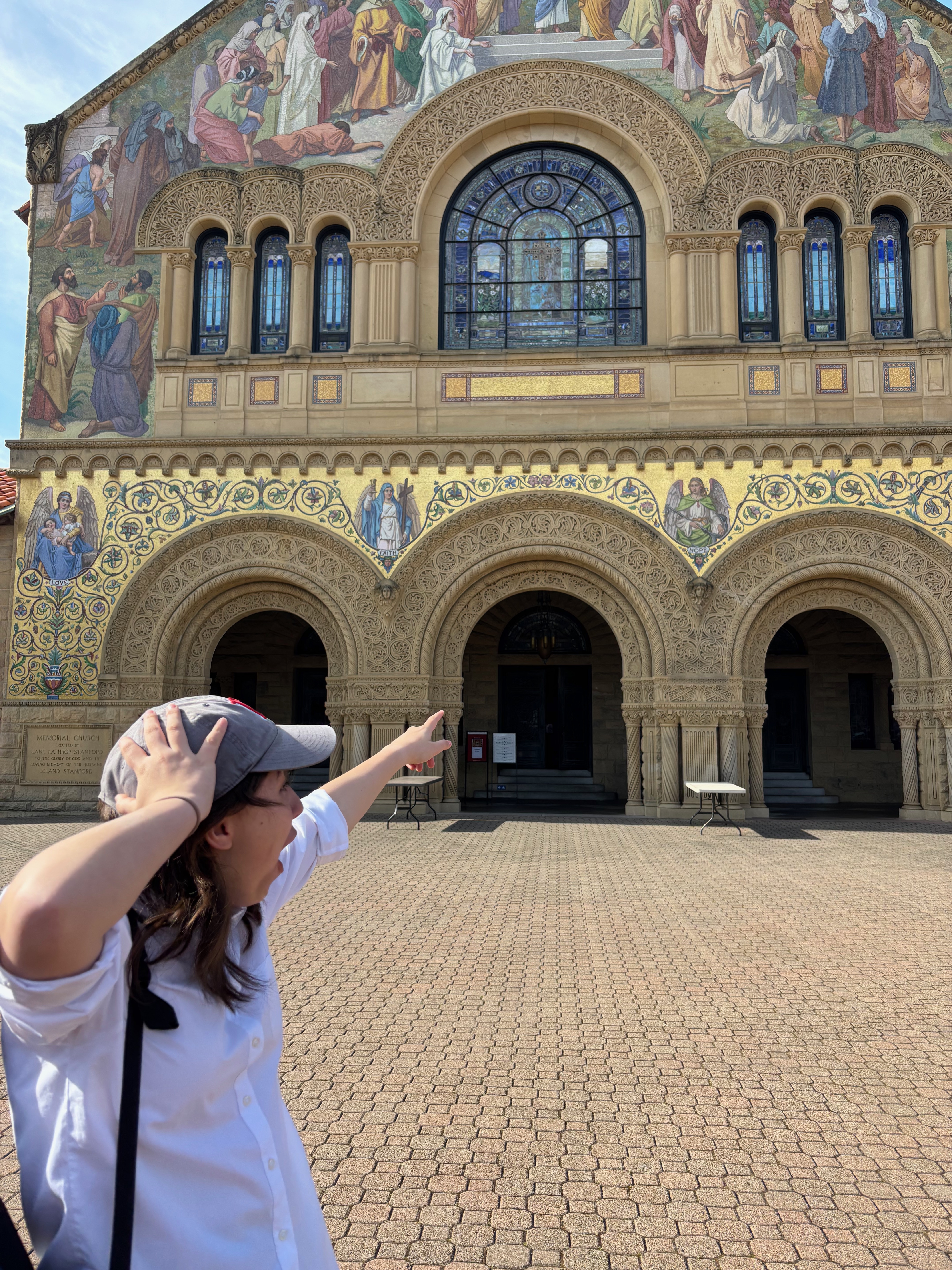 person pointing at stanford memorial church